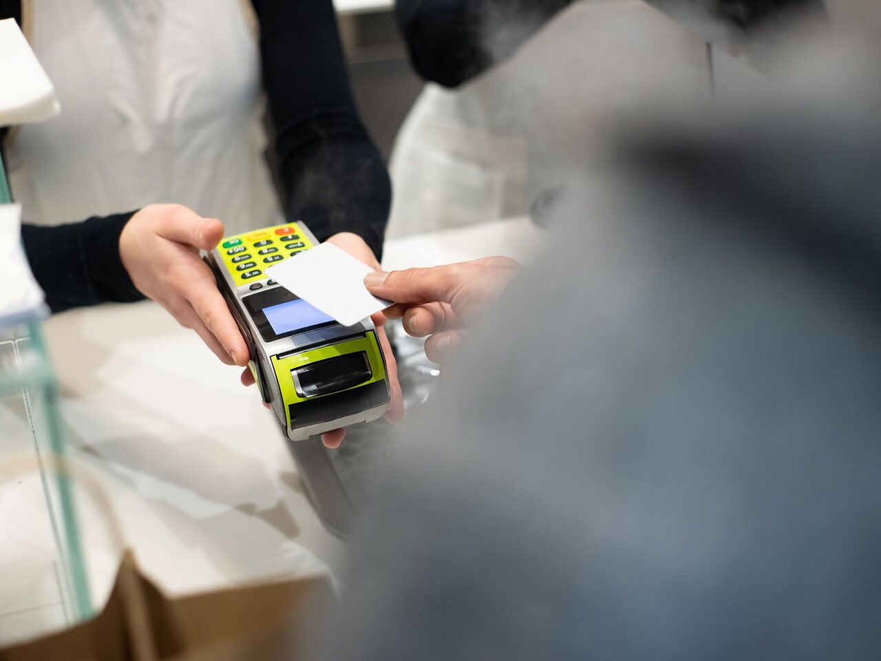 Cliente pagando con tarjeta en el terminal del mesón al retirar a su mascota.